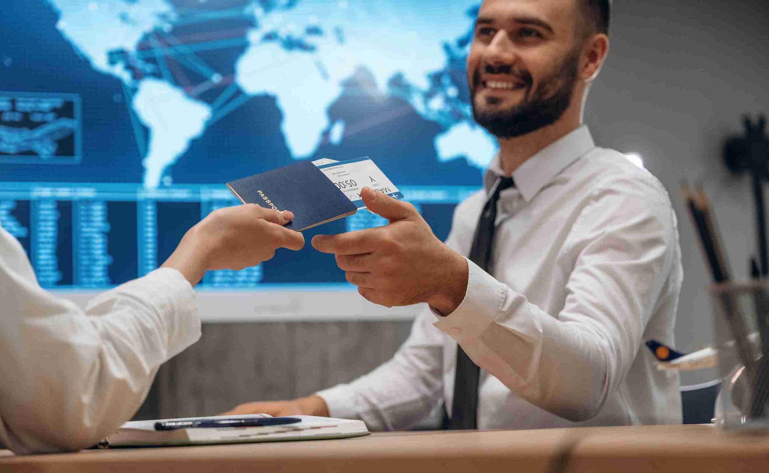 Two people enthusiastically show their passports at a desk, symbolizing their travel aspirations.