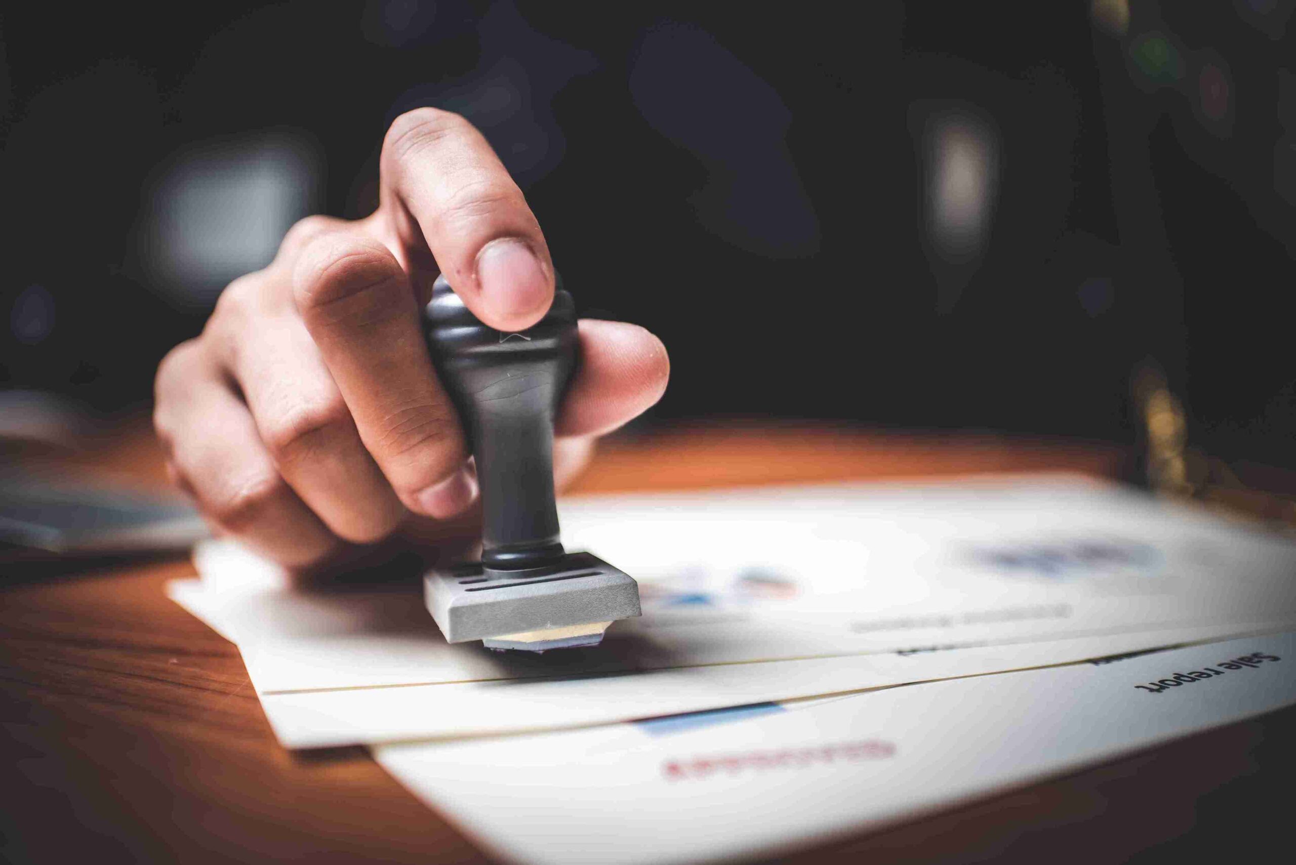 hand-using-stamp-on-approved-documents-at-work