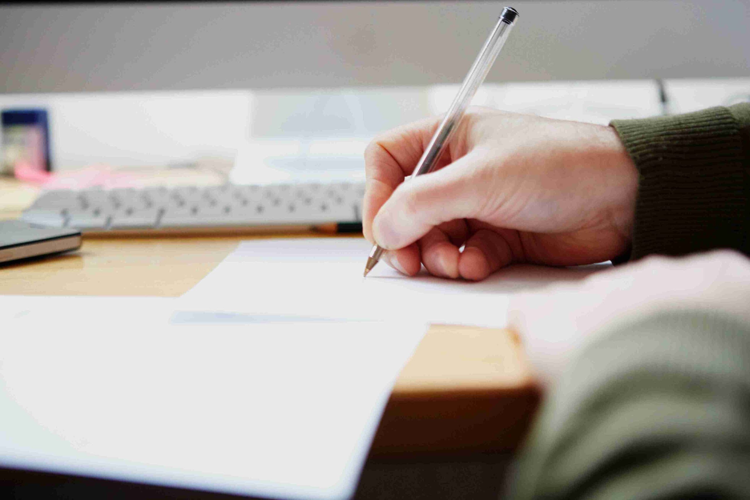 hand-writes-on-paper-at-bright-desk