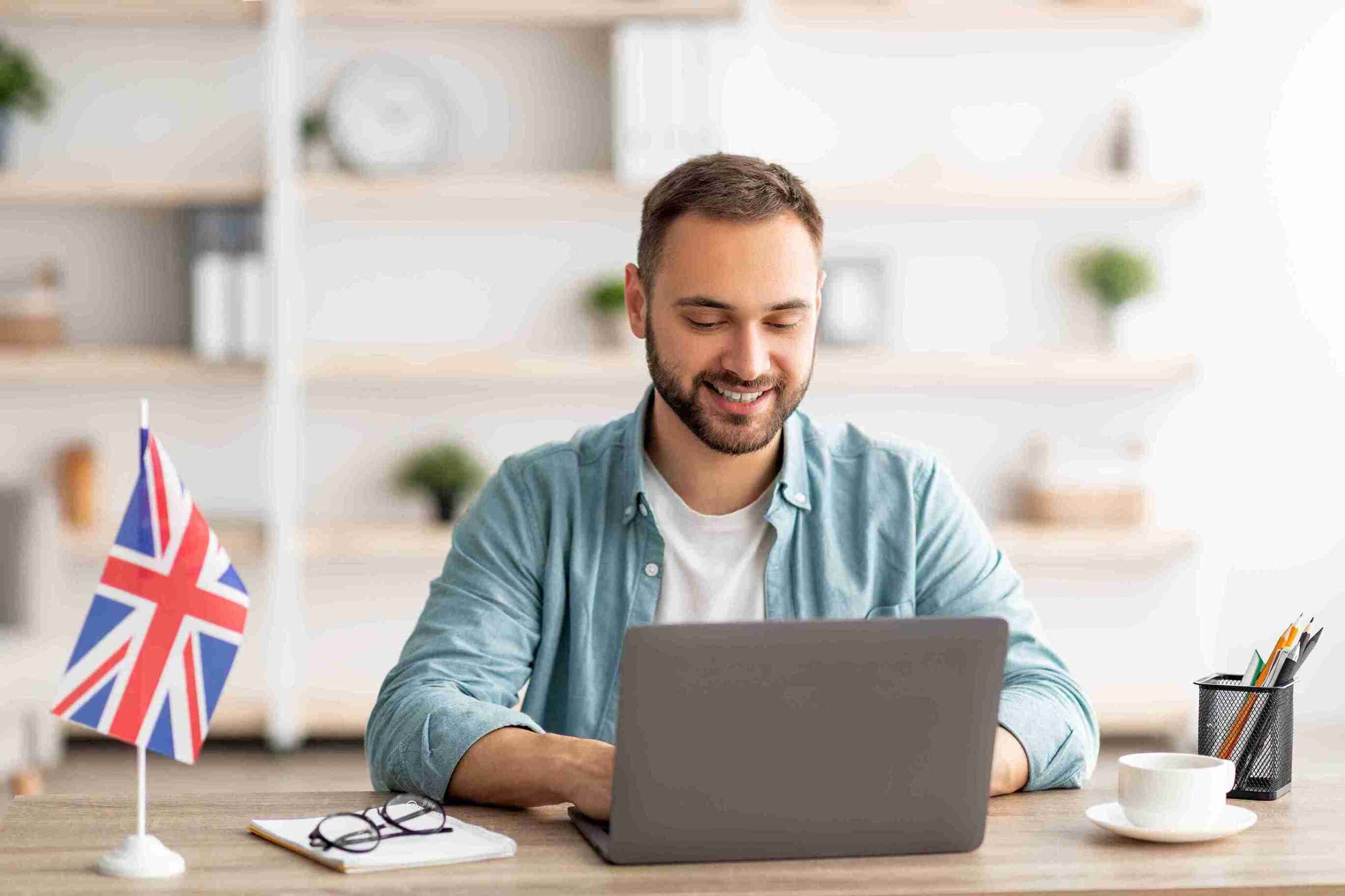 man-smiling-while-using-laptop-at-desk