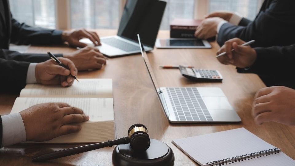 (A team of solicitors along with their client preparing for the long process)