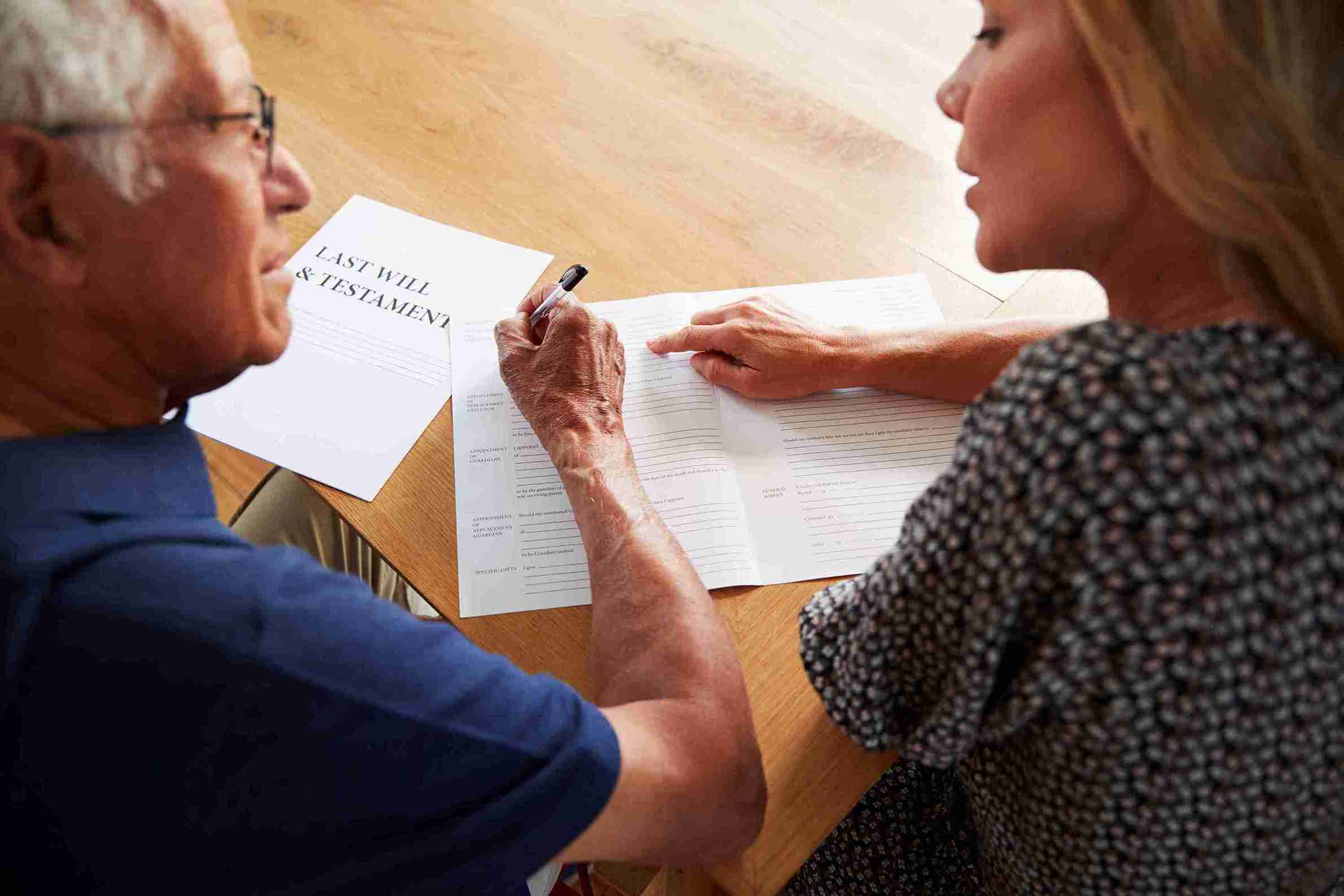senior-man-signs-will-with-woman-s-support