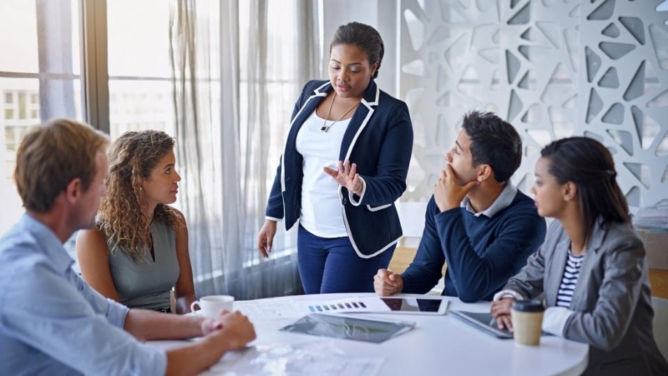 (In the image a group of people can be seen discussing critiques and controversies)

