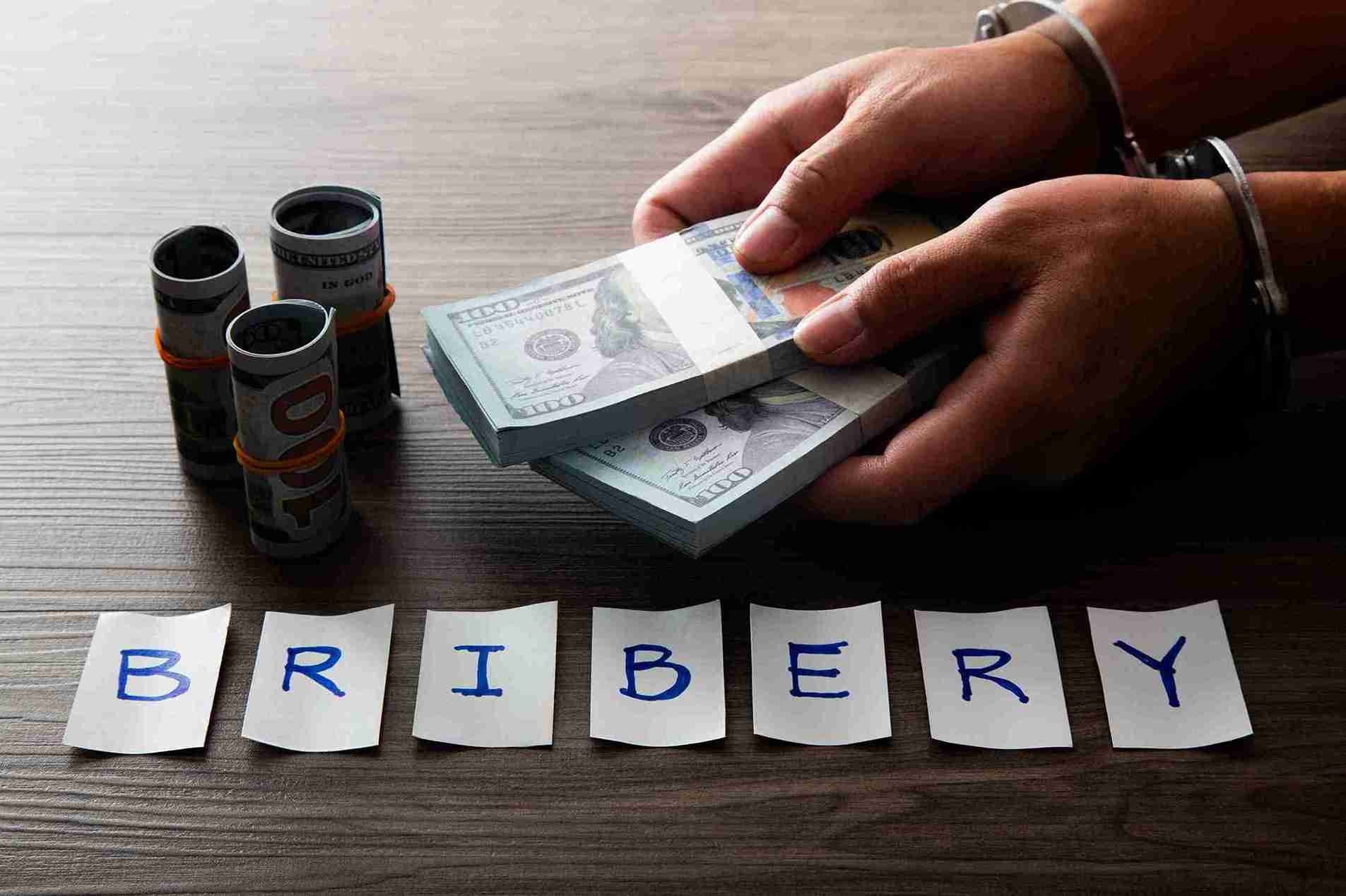 In the image a bribery scene can be seen and a hefty fine in pounds can be seen below
