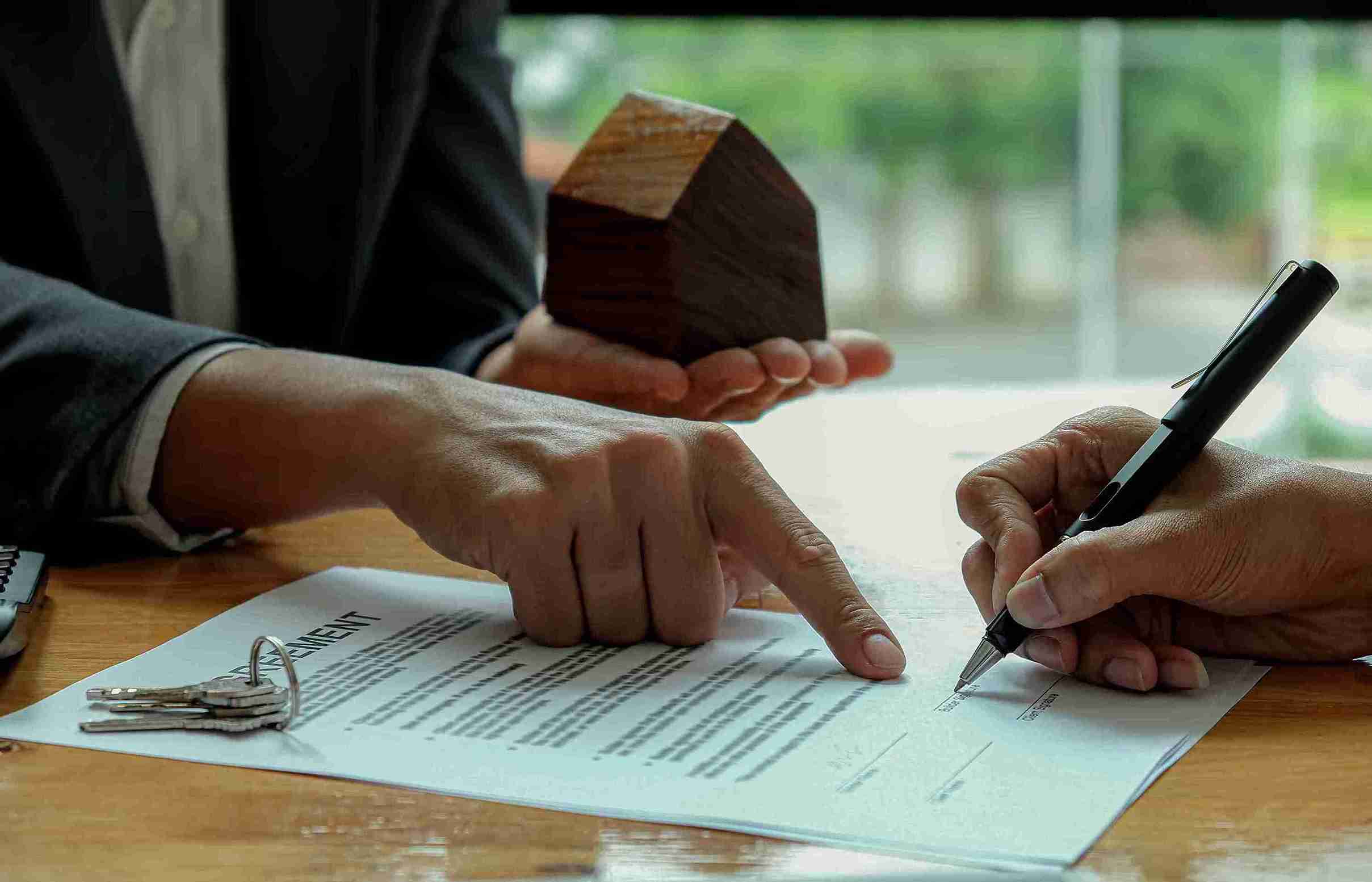 real-estate-transaction-with-model-house-and-contr