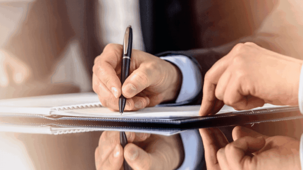 Two individuals jot down thoughts on a notepad, engaged in a productive brainstorming session