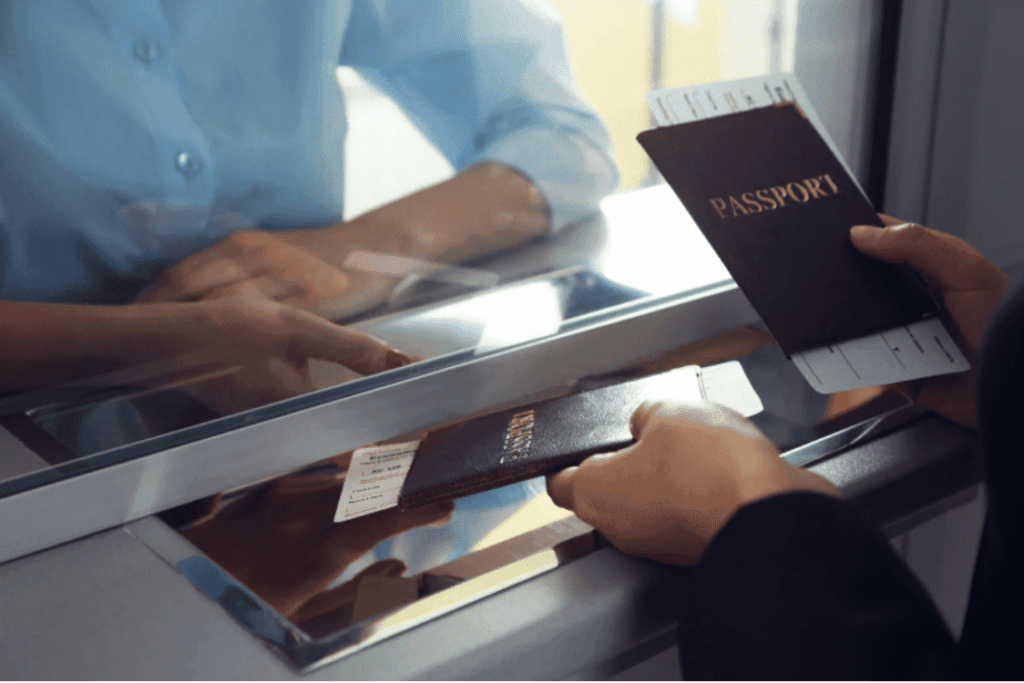 Applicant submitting passport and documents for Skilled Worker visa processing.