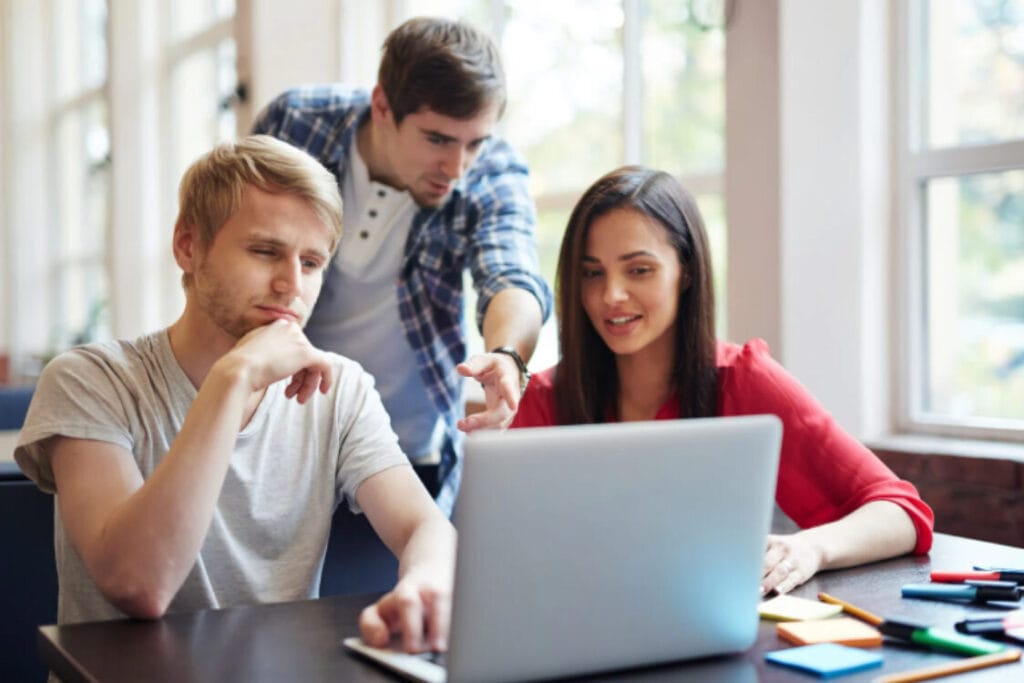 Students reviewing UK visa fees and study requirements online.