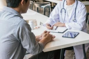 (A healthcare professional in a white coat conducting a consultation, representing the professional registration and assessment process for UK immigration.)