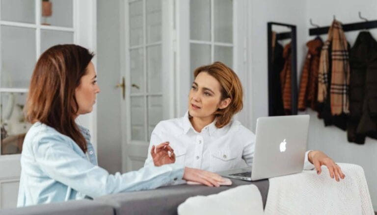 Immigration consultant explaining alternative UK visa options on a laptop to a client.