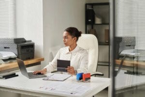 Woman reviewing UK visa application documents and fees on laptop.
