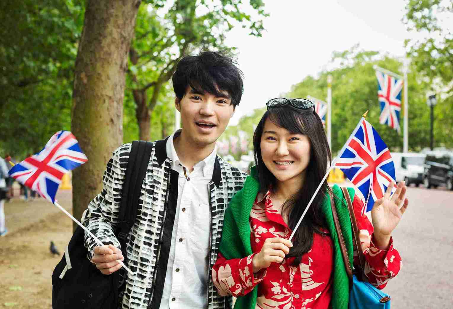 Enthusiastic Travelers With Flags Touring Urban Park.