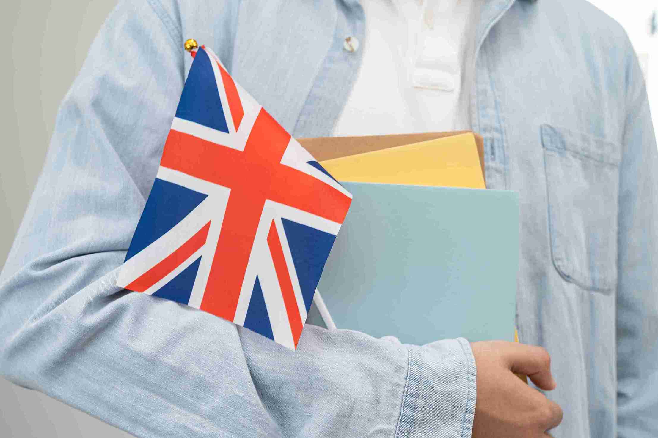 Holding flag of UK with colored books.