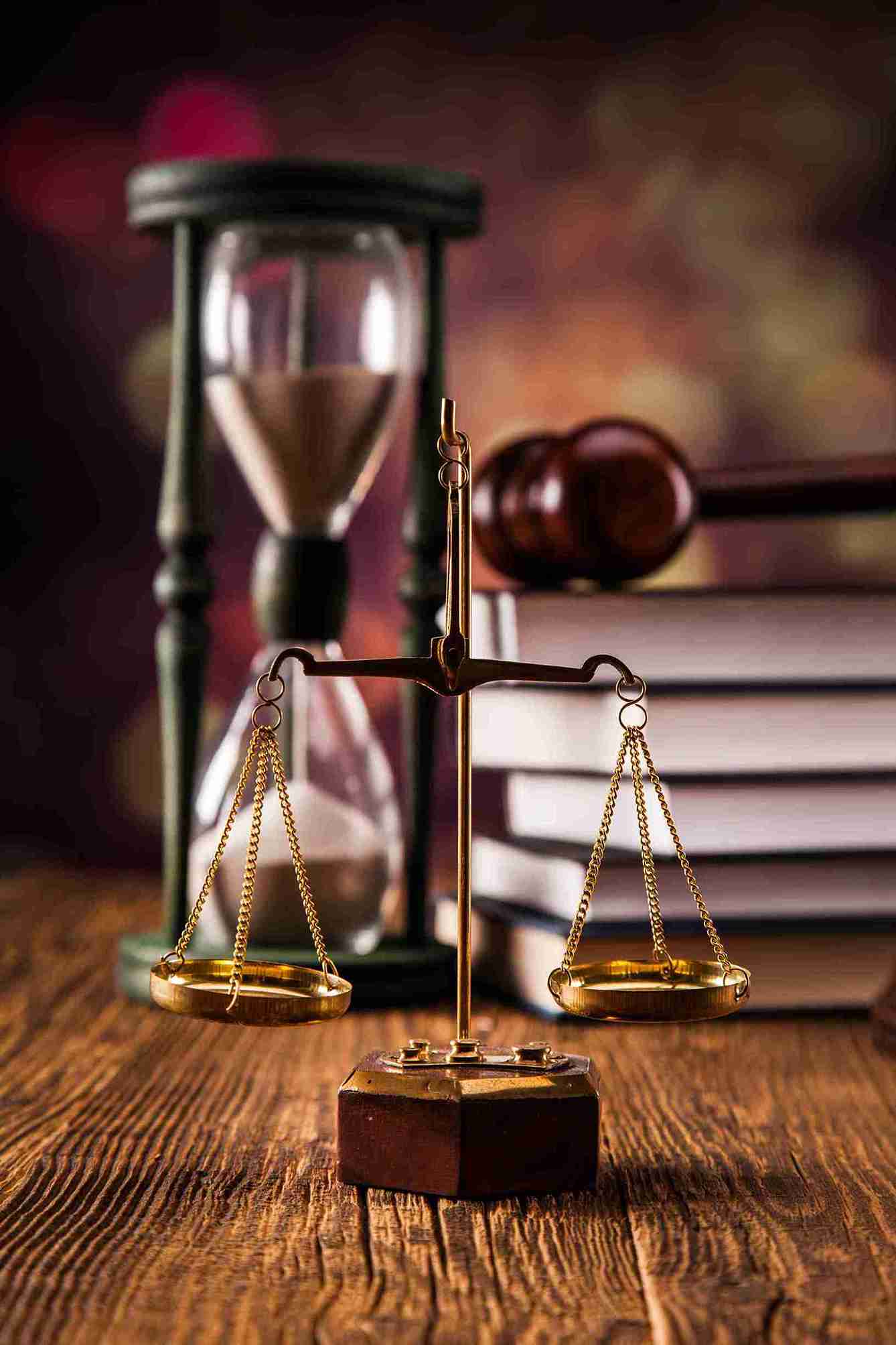 Law books stacked beside a set of scales, symbolizing justice and the legal profession.